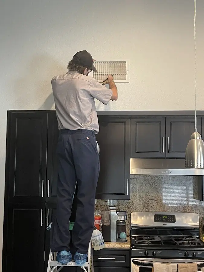 Technician inspecting an air vent during HVAC service in Montpelier